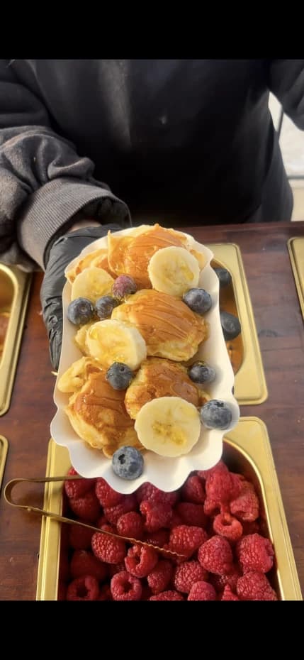 Barquette de mini pancakes avec banane, myrtilles et coulis