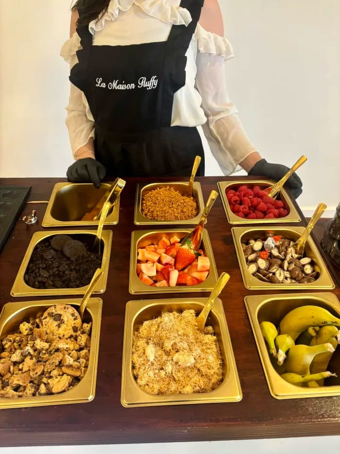 Service La Maison Fluffy derrière le buffet de fruits et toppings